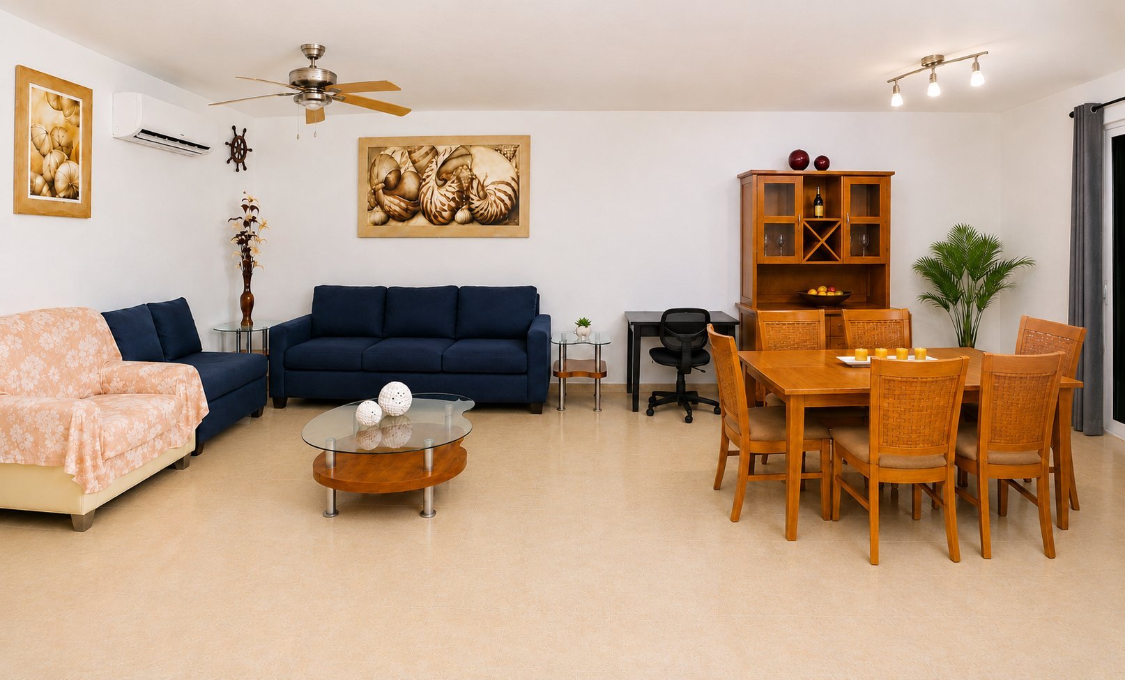 Spacious living room and dining area with dark blue sofa, wooden furniture, and beige flooring throughout
