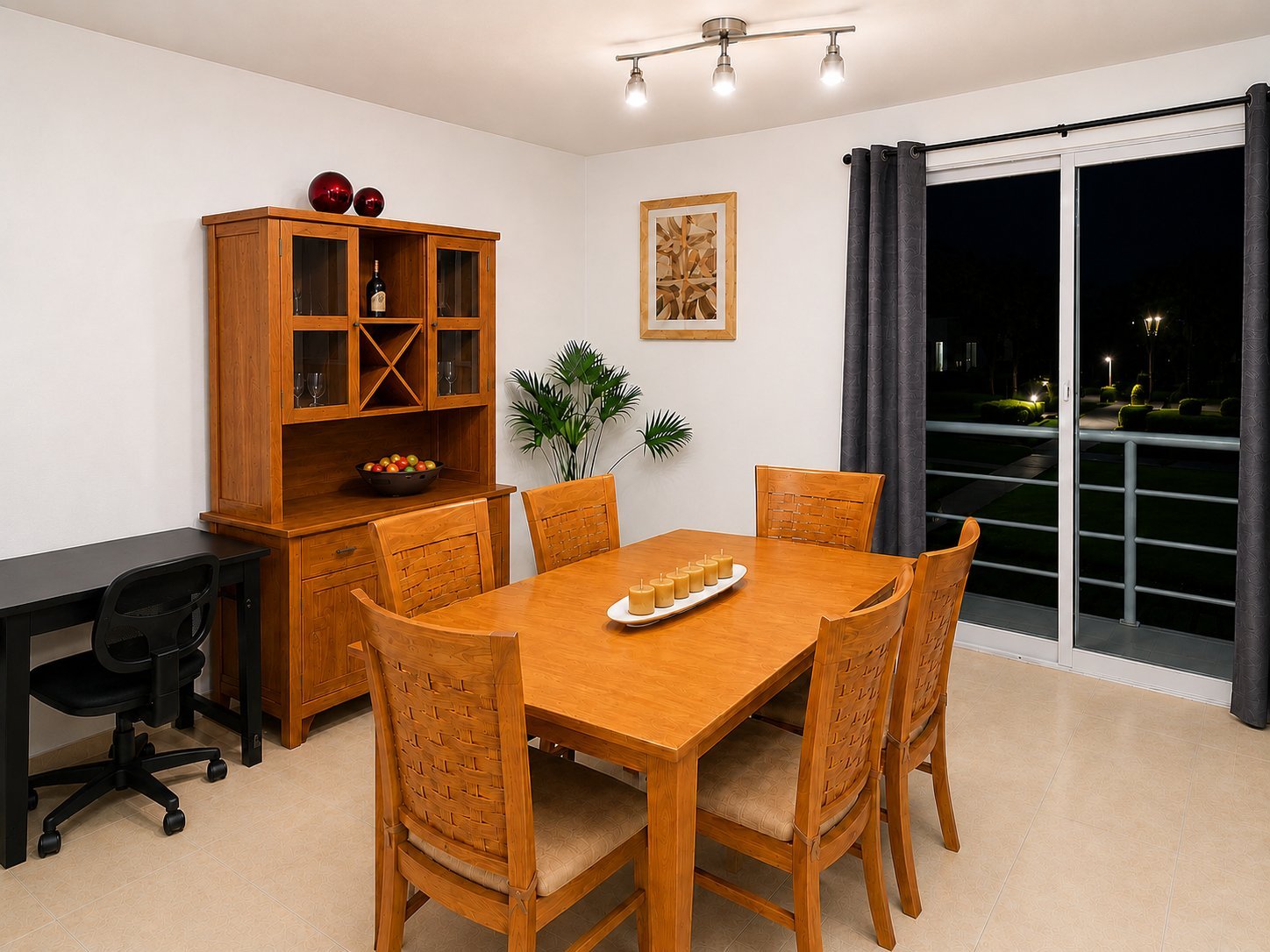 Modern dining room with wooden table and chairs, cabinet with glass doors, black office chair, and large windows with dark curtains