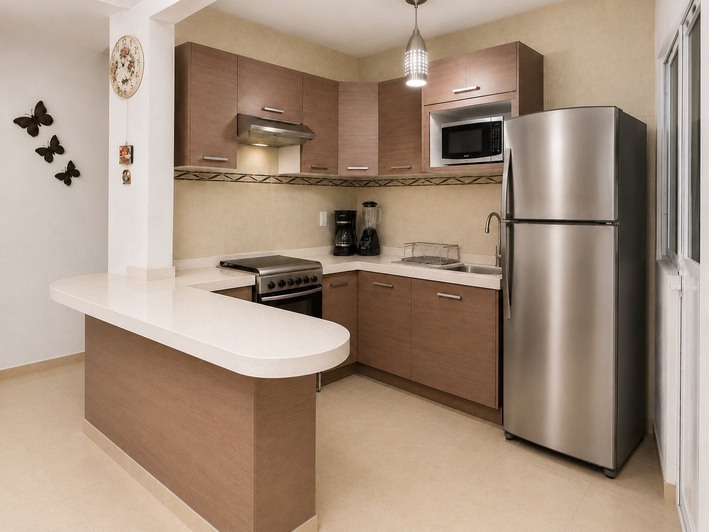 Modern kitchen with brown cabinetry, stainless steel appliances, white countertop island, and pendant lighting.