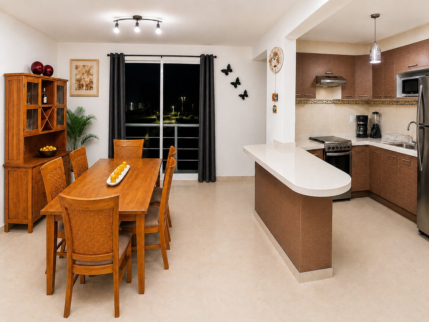 Open-concept kitchen and dining area with wooden furniture, white countertops, and black window treatments